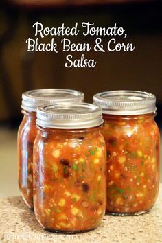 three mason jars filled with roasted tomatoes, black bean and corn salsa