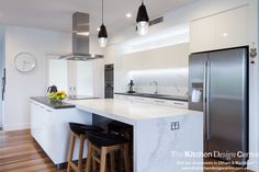 a kitchen with an island and stools next to the counter top in front of it