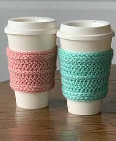 two coffee cups sitting on top of a wooden table