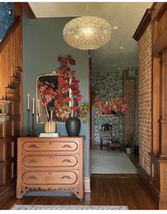 a room with a dresser, mirror and potted plant on it's side