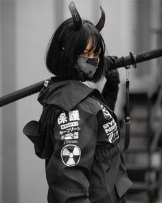 a woman dressed in black with horns and makeup holding a baseball bat on her shoulder