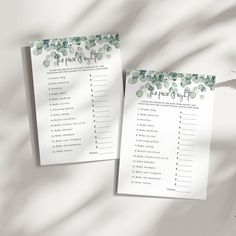 two wedding games with greenery on them sitting next to each other in front of a white background