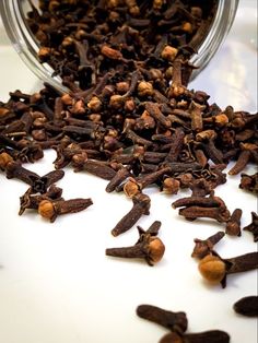 cloves spilled out of a jar onto a white surface