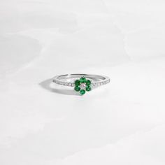 The vibrancy of this emerald flower ring is breathtaking! Emerald represents so many great qualities and is an essential piece in your jewelry collection! This flower ring pairs the beauty of nature just perfectly! The emerald stones are a beautiful vibrant color and it's set against radiant and brilliant cubic zirconia stones that shine so bright. This ring is minimalist and dainty, and great for stacking or worn alone. Makes a great gift to yourself or someone special! At Sami Jewels, we belie Fine Jewelry Green Diamond Ring For May Birthstone, Green Birthstone Ring Fine Jewelry, Elegant Flower Shaped Birthstone Rings, Elegant Flower-shaped Birthstone Rings, Elegant Flower Shape Birthstone Rings, Elegant May Birthstone Flower Ring With Gemstone, Green Flower-shaped Jewelry For Anniversary, Green Flower Shaped Anniversary Jewelry, Green Flower-shaped Anniversary Jewelry