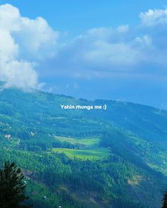 the mountains are covered in green trees and there is a white sign that says yonhn