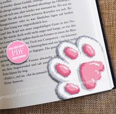 an open book with pink paw prints on it