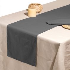 a table topped with a black and white cloth next to a lit candle on top of it