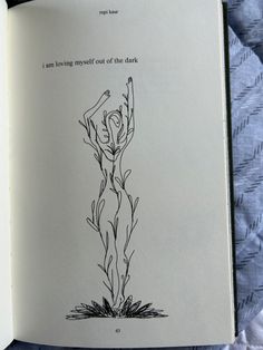 an open book with a drawing of a woman's body on the cover and words above it