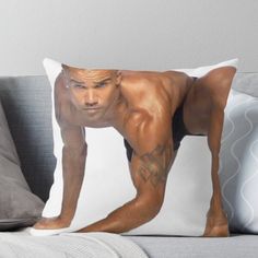 a man with no shirt on is bending down to pose for the camera throw pillow