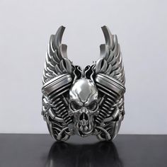 This bold and detailed Engine Skull Auto Wings Ride Ring is crafted from high-quality 925 Sterling Silver, making it the perfect accessory for motorcycle enthusiasts and riders. The intricate design features a fierce skull, auto wings, and mechanical elements, symbolizing speed, power, and freedom. This ring is ideal for bikers, car lovers, and those who appreciate edgy, rugged styles. Its durable material ensures it will stand the test of time, while its unique aesthetic makes it a standout piece in any jewelry collection. Whether you're riding on the open road or looking for a unique gift for the biker in your life, this ring captures the spirit of adventure. Available in various sizes to ensure the perfect fit. ⚜️ Package included: Unisex Silver Ring - Made to order ⚜️ Sizes: From 3 to Masonic Ring, Viking Ring, Retro Ring, Animal Rings, Chunky Rings, Cross Ring, Everyday Rings, Handmade Rings, Gifts For Brother