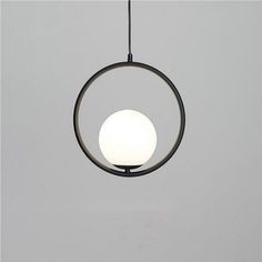 a circular light hanging from a ceiling fixture with a white ball on it's end