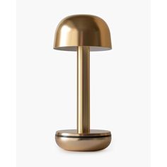 a brass colored table lamp on a white background with the light turned on and off