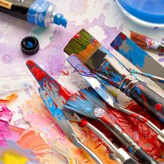 some paint brushes and paints on a table