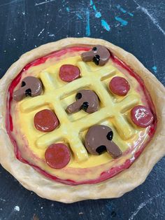 a pizza with different toppings on it sitting on top of a black countertop