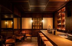 a dimly lit bar with wooden shelves and chairs