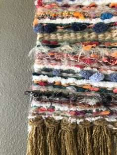 a multicolored wall hanging made out of yarn