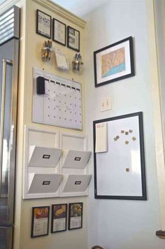 a kitchen wall with pictures and magnets on the refrigerator freezer door is shown