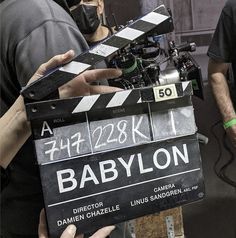 a man holding a clapper in front of a camera