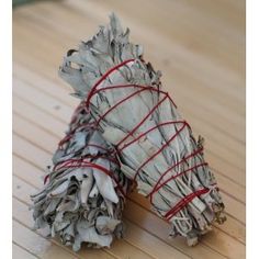 two bundles of white sage sitting on top of a wooden table