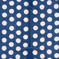 a blue and white polka dot fabric with a house in the middle on top of it