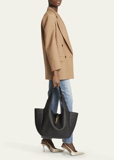 "Find SAINT LAURENT Bea Ysl Tote Bag In Deer Leather on Editorialist. Saint Laurent \"Bea\" tote bag in deer leather Shoulder straps Open top with YSL logo strap Interior, one zip pocket Golden hardware Approx. 11\"H x 19.6\"W x 7.1\"D Professional cleaning recommended Made in Italy"