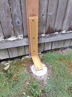 a wooden pole sticking out of the ground next to a fence