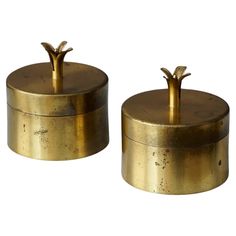 two brass canisters sitting side by side