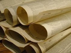 several rolled up newspapers sitting on top of a wooden table