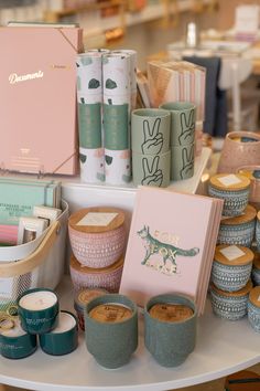 the table is full of candles and other items for sale at the store's booth