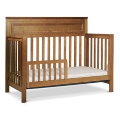 a wooden crib with white sheets on the bottom and side rails, against a white background