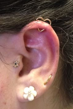 a close up of a person's ear with two different piercings on it