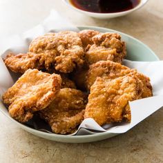 some fried food in a bowl on a table next to a cup and saucer