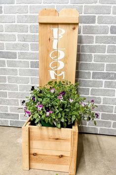 a wooden planter with purple flowers in it