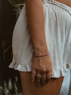 a woman's arm with a small star tattoo on it