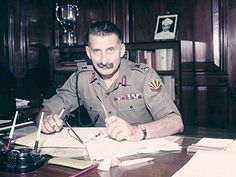 a man in uniform sitting at a desk with papers