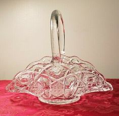 a glass dish with a handle on a red table cloth