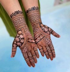 two hands with henna designs on them