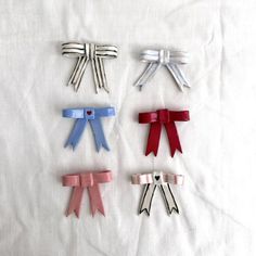 four different colored bows on a white sheet