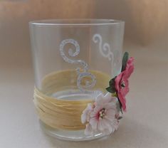 a close up of a glass on a table with flowers in the middle and an ombrella