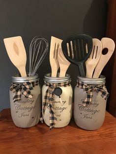 three mason jars with wooden utensils in them