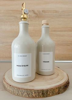 two white bottles sitting on top of a wooden stand