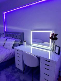 a white desk with a mirror and chair in a room that has purple lighting on the walls