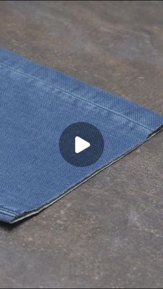 a blue cloth with a play button on the bottom and an arrow in the middle