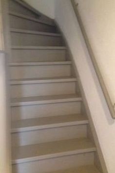 an empty staircase leading up to the top floor in a home or office building with white walls and carpeted floors