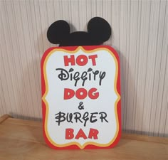 a sign that says hot dog and burger bar with mickey mouse ears on the top