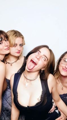 three women are posing for the camera with their mouths open and one woman is sticking out her tongue