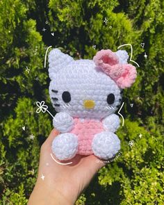 a small crocheted hello kitty sitting on top of a tree