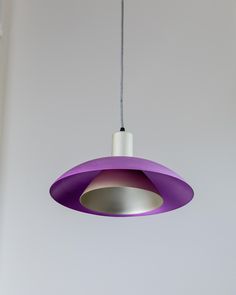 a purple and white light hanging from a ceiling