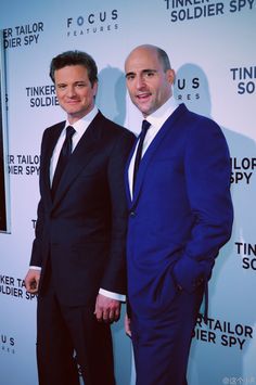 two men in suits and ties posing for the camera on the red carpet at an event