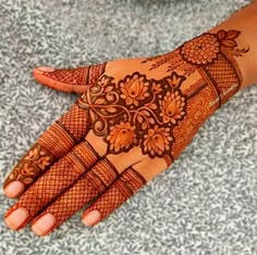 a woman's hand with henna tattoos on it